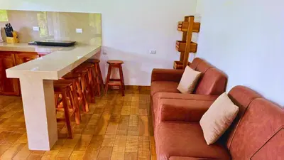 a living room with a table and a couch and a counter at Rio Celeste Birds Garden Apartment with Air Conditioning Comfort and Privacy in a Natural Environment 3 in Upala