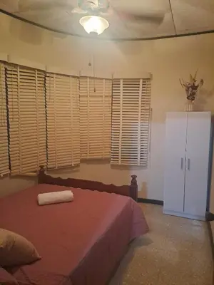 a bedroom with a bed and a white refrigerator at CasaLinda Liberia, Guanacaste in Liberia