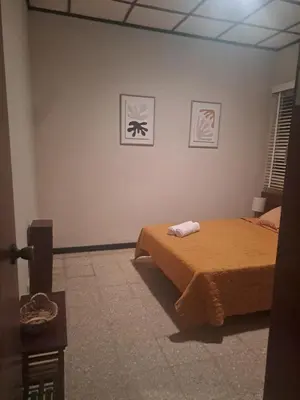 a bedroom with a bed and two pictures on the wall at CasaLinda Liberia, Guanacaste in Liberia