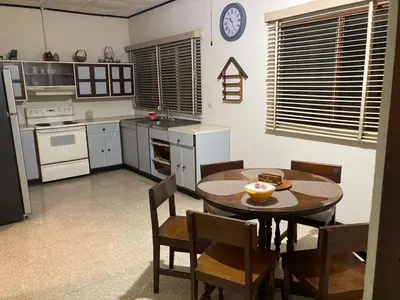 a kitchen with a table and chairs and a clock on the wall at CasaLinda Liberia, Guanacaste in Liberia