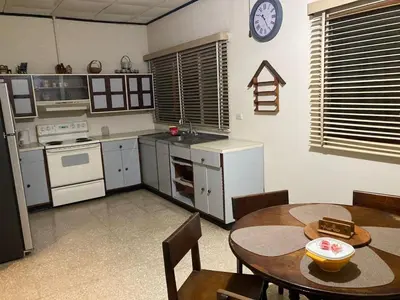 a kitchen with a table and a clock on the wall at CasaLinda Liberia, Guanacaste in Liberia