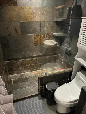 a bathroom with a toilet and a glass shower at Oasis Lodge in La Asunción