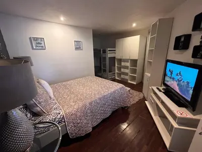 a bedroom with a bed and a flat screen tv at Oasis Lodge in La Asunción