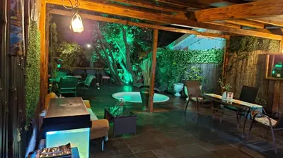 a patio with a tree and a table and chairs at Oasis Lodge in La Asunción