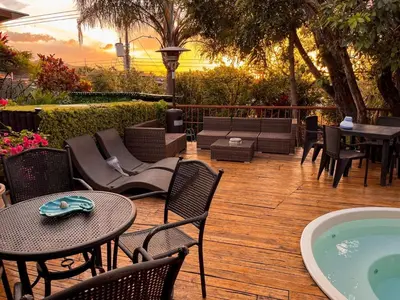 a patio with tables and chairs and a hot tub at Oasis Lodge in La Asunción