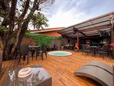 a patio with a table and chairs and a pool at Oasis Lodge in La Asunción
