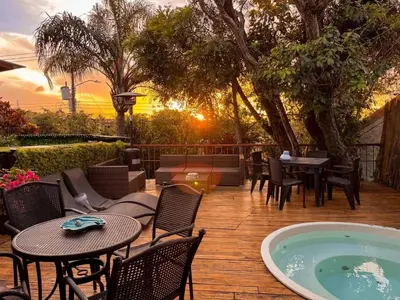 a patio with tables and chairs and a hot tub at Oasis Lodge in La Asunción
