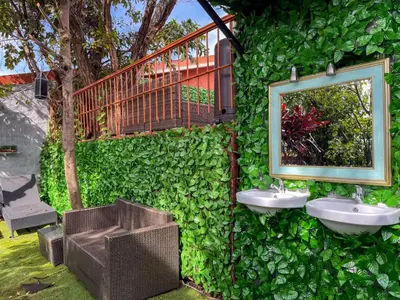 a green wall with two sinks and a mirror at Oasis Lodge in La Asunción