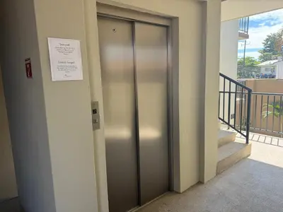 an elevator in a building with a sign on the wall at Monaco Condominiums Unit 7 Luxury Pool View Condo 3BR 2BA - Walk to the Beach, Shopping, Tours in Jacó