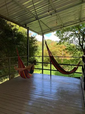a woman laying in a hammock on a deck at Casa Dama Santa María de Dota in Santa María