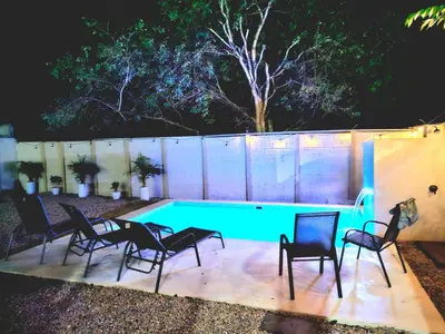 a group of chairs around a swimming pool at night at Casa Matapalo Guanacaste in Matapalo