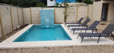 a swimming pool with chairs in a backyard at Casa Matapalo Guanacaste in Matapalo