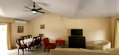 a living room with a table and chairs and a ceiling fan at Casa Matapalo Guanacaste in Matapalo
