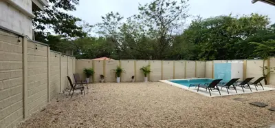 a backyard with a pool and chairs and a fence at Casa Matapalo Guanacaste in Matapalo