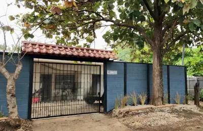 a blue building with a dog in a cage at Casa Matapalo Guanacaste in Matapalo