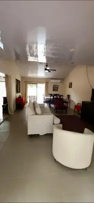 a living room with two white couches and a table at Casa Matapalo Guanacaste in Matapalo