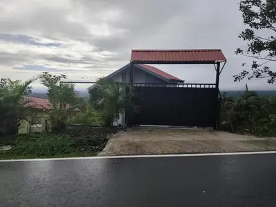 a house with a red roof on the side of a road at Villas Altos de el Arenal # 2 in Monterrey