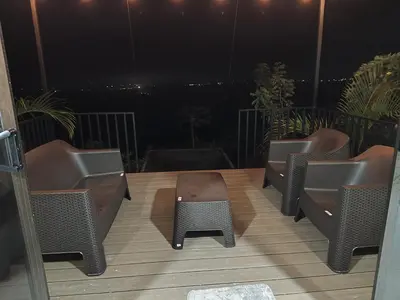 three chairs and a table on a balcony at night at Villas Altos de el Arenal # 2 in Monterrey