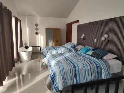 a bedroom with a bed with a striped comforter at Villas Altos de el Arenal # 2 in Monterrey