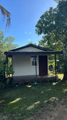 a small house with a porch in a yard at Casa lapas in San Isidro