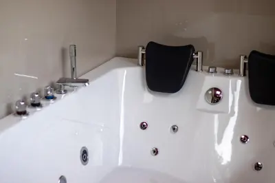 a white bath tub with two chairs in a bathroom at Cabaña Refugio Verde Arenal in Fortuna
