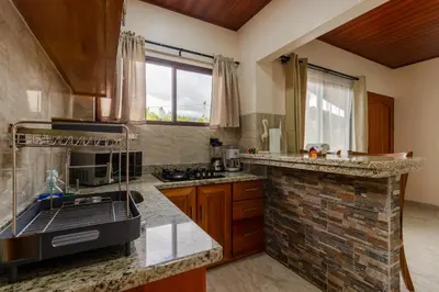 a kitchen with a sink and a stove top oven at Cabaña Refugio Verde Arenal in Fortuna