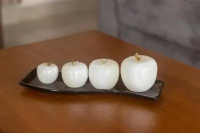 four white apples on a plate on a table at Cabaña Refugio Verde Arenal in Fortuna