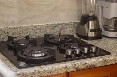 a black stove top on a counter in a kitchen at Cabaña Refugio Verde Arenal in Fortuna