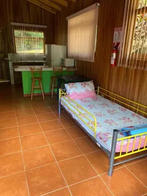 a bedroom with a bed and a kitchen with a table at Cabañas Luz de Luna
