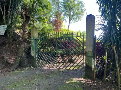 a metal gate with a wooden post in a garden at Cabañas Luz de Luna