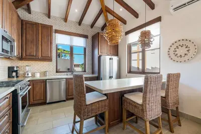 a kitchen with wooden cabinets and a table and chairs at Bright Modern Home with Beach Club Access and Walking Distance to the Beach in Playa Danta