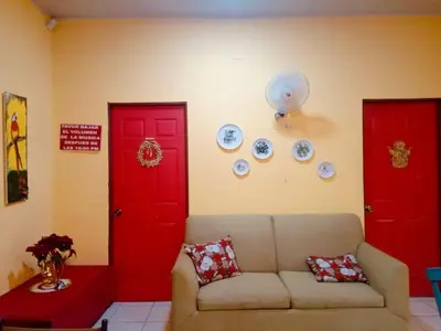 a living room with red doors and a couch at Casa para vacacionar Orotina in Orotina