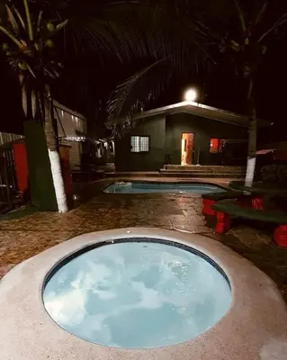 a large swimming pool in front of a house at night at Casa para vacacionar Orotina in Orotina