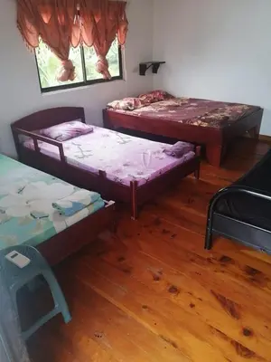 three beds in a room with wooden floors at Casa Elenia in Bahia