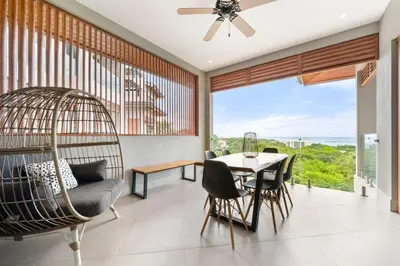 a dining room with a swing and a table and chairs at Panaromic Oceanview Luxury 3BR Private Rooftop in Tamarindo