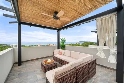 a patio with a couch and a ceiling fan at Panaromic Oceanview Luxury 3BR Private Rooftop in Tamarindo