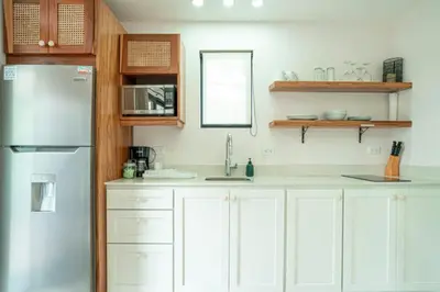 a kitchen with white cabinets and a refrigerator at Peaceful 1BR Casita with Private Deck Near Tamarindo in Tamarindo