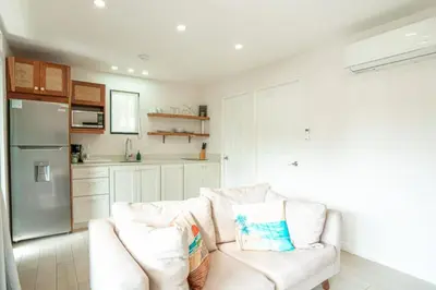 a living room with a white couch and a kitchen at Peaceful 1BR Casita with Private Deck Near Tamarindo in Tamarindo