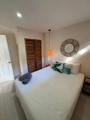 a bedroom with a large white bed and a mirror at Peaceful 1BR Casita with Private Deck Near Tamarindo in Tamarindo