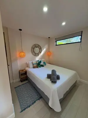 a bedroom with a large white bed with a window at Peaceful 1BR Casita with Private Deck Near Tamarindo in Tamarindo