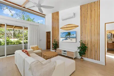 a living room with a white couch and a large window at Peaceful Jungle Escape with Private Pool in Playa Grande