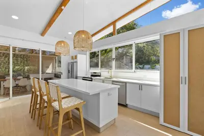 a kitchen with white cabinets and a large window at Peaceful Jungle Escape with Private Pool in Playa Grande