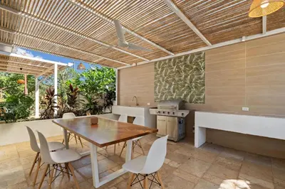 a kitchen and dining room with a wooden table and chairs at Peaceful Jungle Escape with Private Pool in Playa Grande