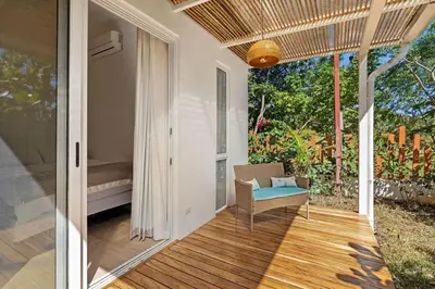a porch of a house with a chair and a window at Peaceful Jungle Escape with Private Pool in Playa Grande