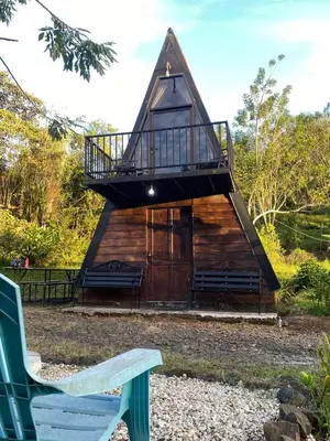 a small cabin with a balcony and a bench at Cabaña La paz in Alajuela City