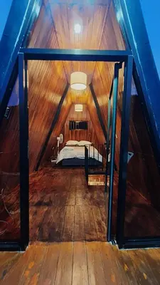 a room with a bed in the middle of a attic at Cabaña La paz in Alajuela City