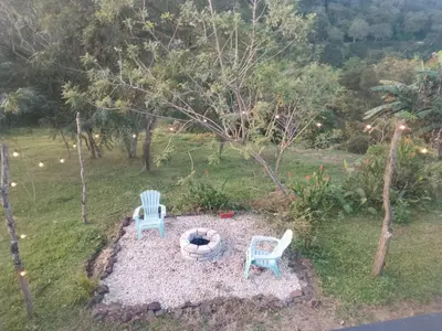 two chairs and a fire pit in a yard at Cabaña La paz in Alajuela City