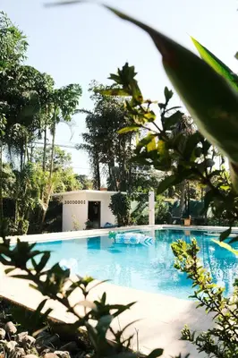 a large blue swimming pool in front of a house at La Buena Vida in Nicoya
