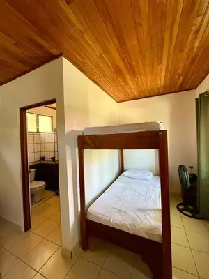 a bedroom with a bunk bed and a bathroom at La Buena Vida in Nicoya