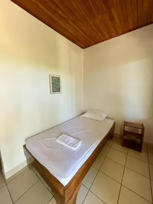 a bed in a room with a wooden ceiling at La Buena Vida in Nicoya